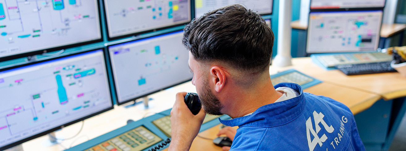 Operator using simulators on multiple screens in an industrial training environment