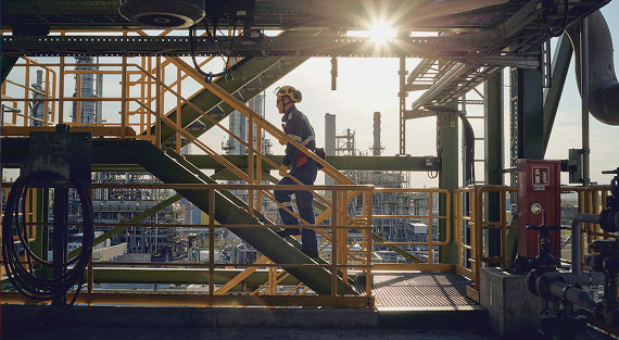 Technician in an industrial oil facility illustrating energy resource extraction